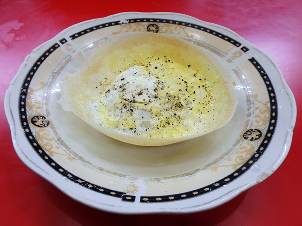 夕方から食堂の店先で作られている、お椀型のクレープ"ホッパー。米粉にココナッツミルクを入れて焼かれたもので、卵入りのエッグホッパーは1つ約30円