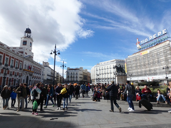 マドリッド自治政府庁に面する広場、プエルタ・デル・ソル Puerta del Sol。多くの人で賑わっているこの広場は町の中心で、スペインの0km地点
